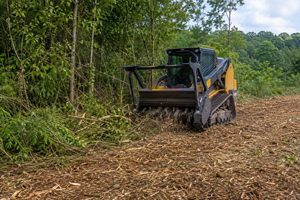 Forestry mulcher clearing dense brush and small trees on an overgrown wooded property